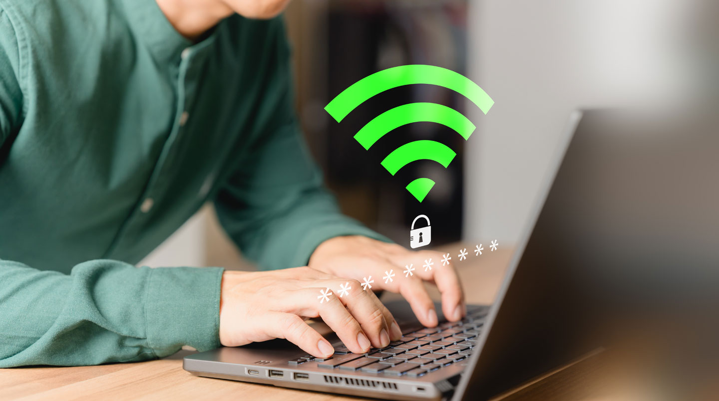 Vue grand angle d'un bureau à domicile dans un appartement français, ordinateur portable ouvert avec icône wifi sécurisé visible à l'écran, lumière naturelle fenêtre